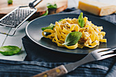 Fettuccine with parmesan and lemon sauce and fresh basil leaves