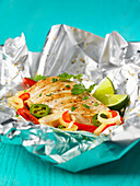 Chicken cooked in foil with coriander, limes and peppers