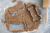 Dough and a bone-shaped cookie cutter for dog biscuits