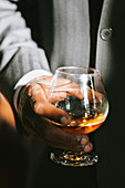 Mann hält ein Glas Bourbon Whiskey