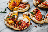 Grilled homemade pizza with tomatoes, basil and mozzarella