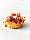 Fried potato and cheese cup with ham, egg and tomato relish