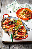 Spaghetti Puttanesca with fish fillets and olives