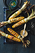 Three grilled corn on the cobs