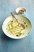Clear asparagus soup with chervil oil