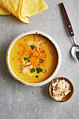 Orange and pepper soup with turmeric and coconut chips