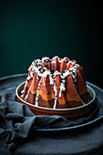 Tri-coloured vegan Bundt cake with icing and chocolate sprinkles