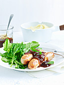 Chicken sausages with sage and onion sauce served with rocket salad