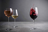 Rotweinglas mit Splash daneben Rosewein- und Weissweinglas