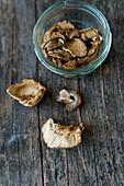 Dried porcini mushrooms in a jar on a wooden surface