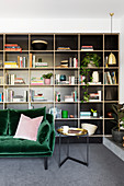 Dark green velvet sofa against a black shelf