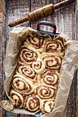 Unbaked cinnamon buns with a rhubarb filling in an old baking tin