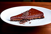 A slice of chocolate tart on a white plate