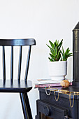 Black spoke-back chair next to stove with modern jewellery on top