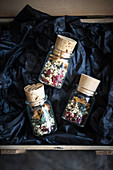 Small jars of loose leaf tea made from dried elderflowers, mint, strawberries and peach
