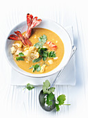 Coconut and cauliflower soup with prawns and herbs