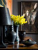 Black lamp and black vase of yellow calla lilies