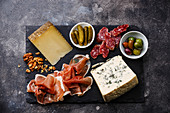 Italian snacks food with Prosciutto, Olive, Cheese and Sausage on dark background