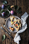 Crepes with figs and blackberries on wooden table