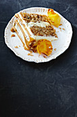 A slice of hummingbird cake with pineapple, bananas, grated coconut, pecan nuts, caramel sauce, cream cheese, cinnamon and whisky