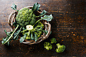 Frischer Brokkoli im Korb auf Holztisch (Aufsicht)