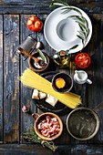 Ingredients for traditional italian pasta: Uncooked spaghetti, tomatoes, pancetta bacon, parmesan cheese, egg yolk, salt, pepper