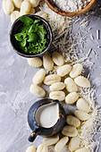 Raw uncooked potato gnocchi in black wooden plates with ingredients