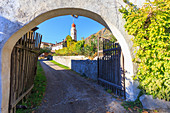 A view through an archway of the village of Partschins and the church, Vinschgau, South Tyrol, Italy