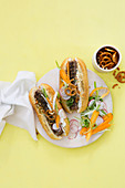 Hot dogs with boerewors (barbecue sausages, South Africa), carrot salad and salt pretzels