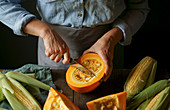 A woman slicing a pumpkin