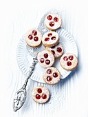 Linzer Augen (nutty shortcrust jam sandwich biscuits with holes on top) with icing sugar
