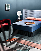 Double bed with individual headboard, blue blanket and pillows