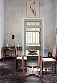 Dining table with glass top, antique chairs and French style console table in the dining room