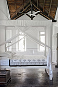Double bed with white canopy in the bedroom