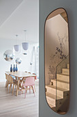 Treppe im ovalen Spiegel vorm modernen Esstisch