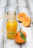 Mandarinensaft in Flasche mit Strohhalm