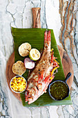 Roasted red mullet with garlic on a banana leaf