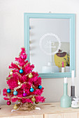 Hot pink Christmas tree next to mirror etched with Christmas greeting