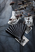 Paper fan and black and white pictures on black fabric