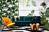 Green velvet sofa and houseplants in exotic living room