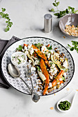 Lentil salad with roasted carrot, fennel, almonds and feta cheese on white table