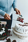 Girl slicing a cake on a white table