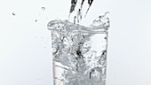 Water overflowing from glass, slow motion