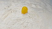 Egg falling into flour, slow motion