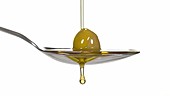 Olive on spoon with oil, slow motion