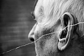 Elderly man using a hearing aid