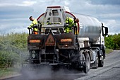 Spraying bitumen during road resurfacing