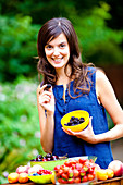 Woman holding summer fruits