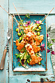 Grilled marinated scampi skewers with a sweet and sour cucumber salad