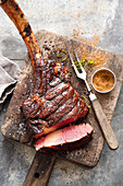 Grilled marinated tomahawk steak with a malt beer mop